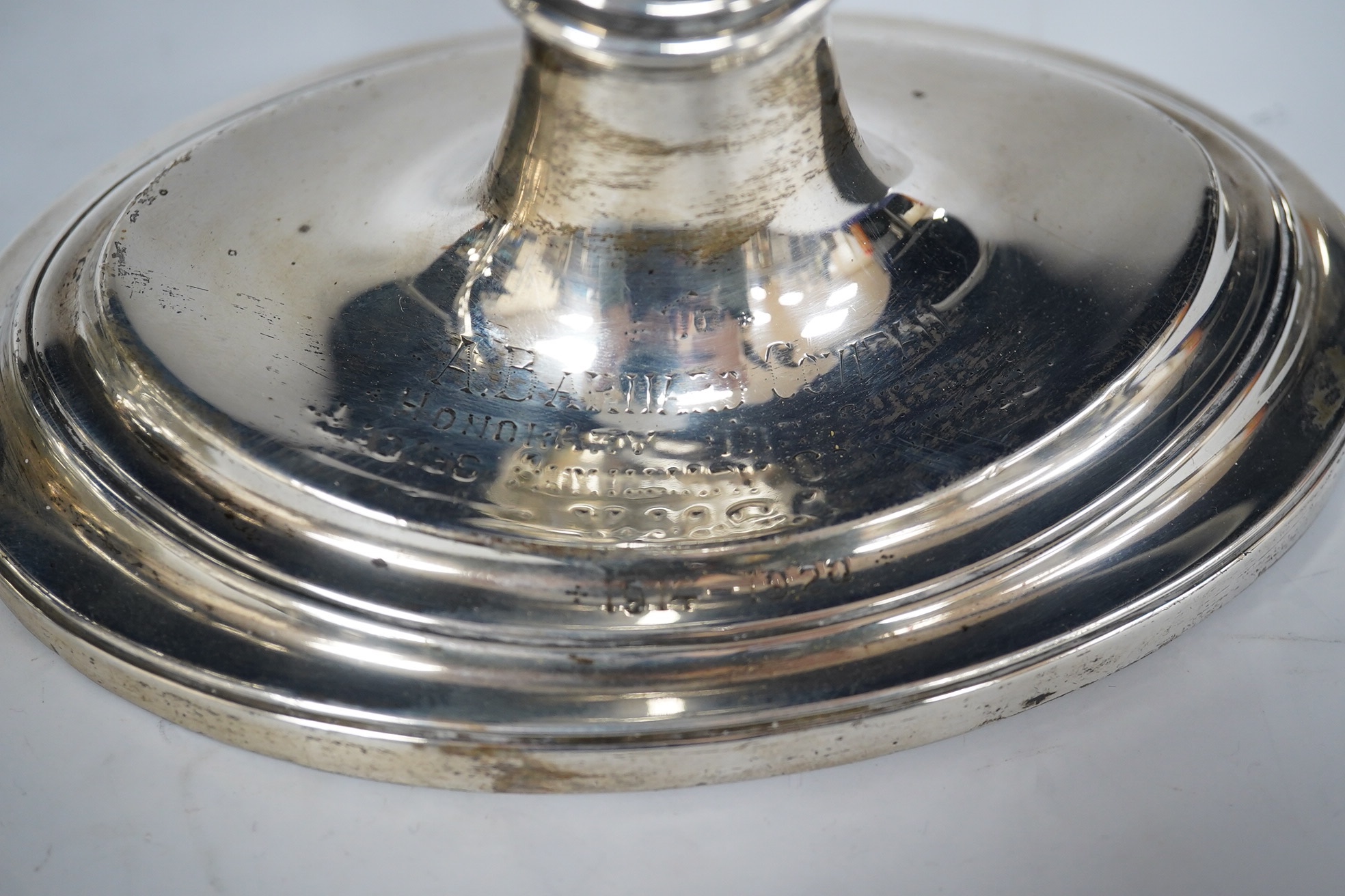 A pair of George V silver oval candlesticks, with engraved inscription, Hawksworth, Eyre & Co, Sheffield, 1919, 30cm, weighted. Condition - fair